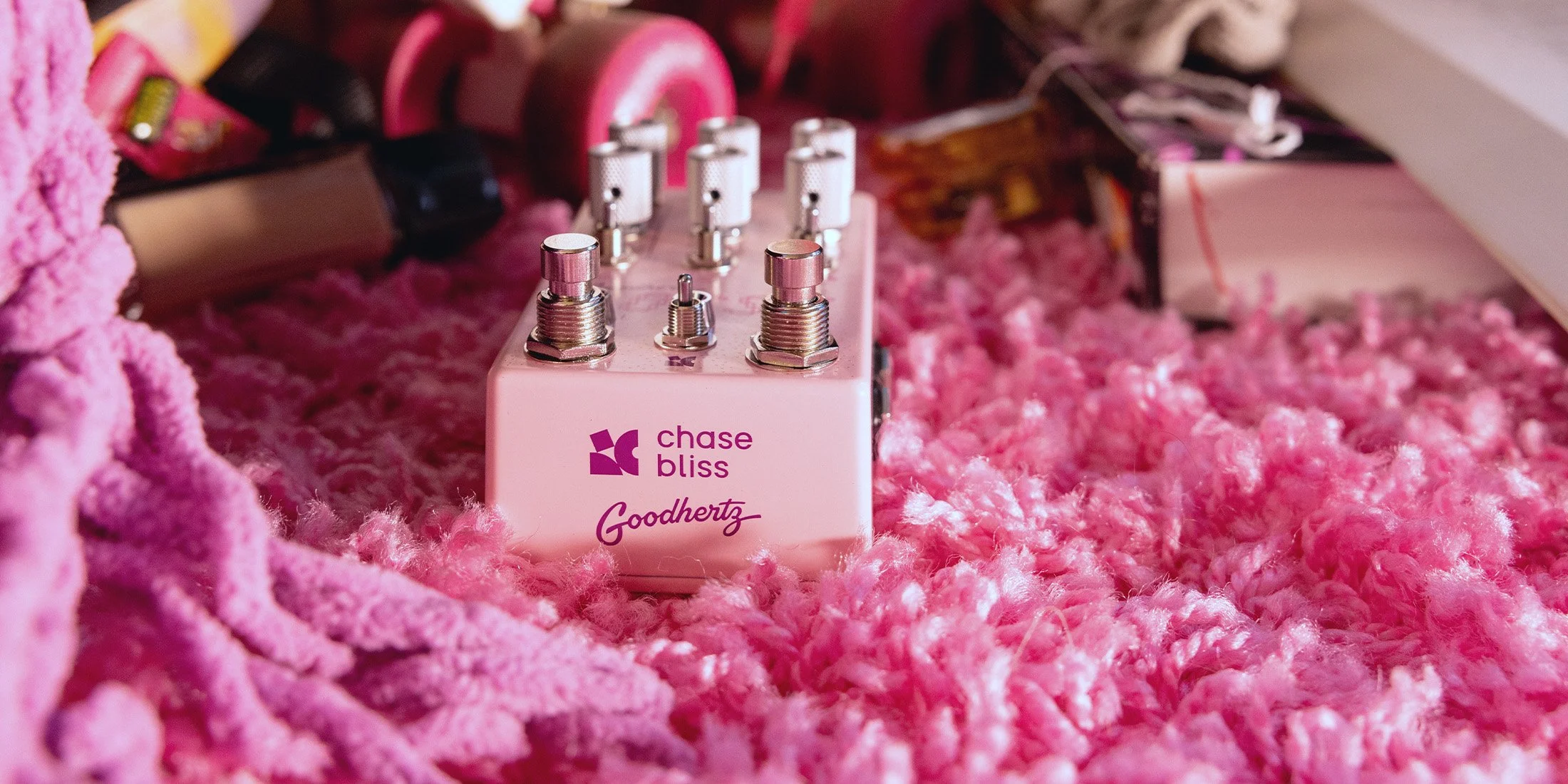 Lossy pedal by Chase Bliss and Goodhertz on a pink shag rug.